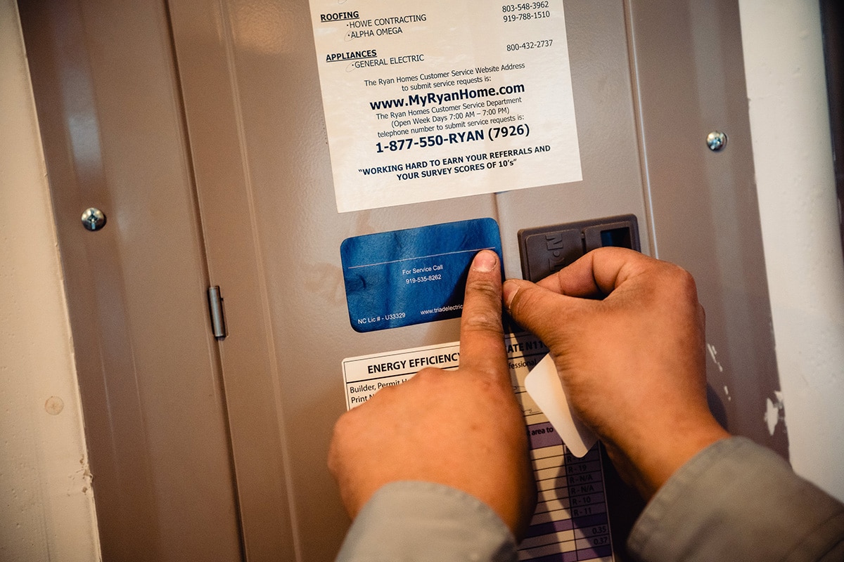 electrician putting sticker on electric panel