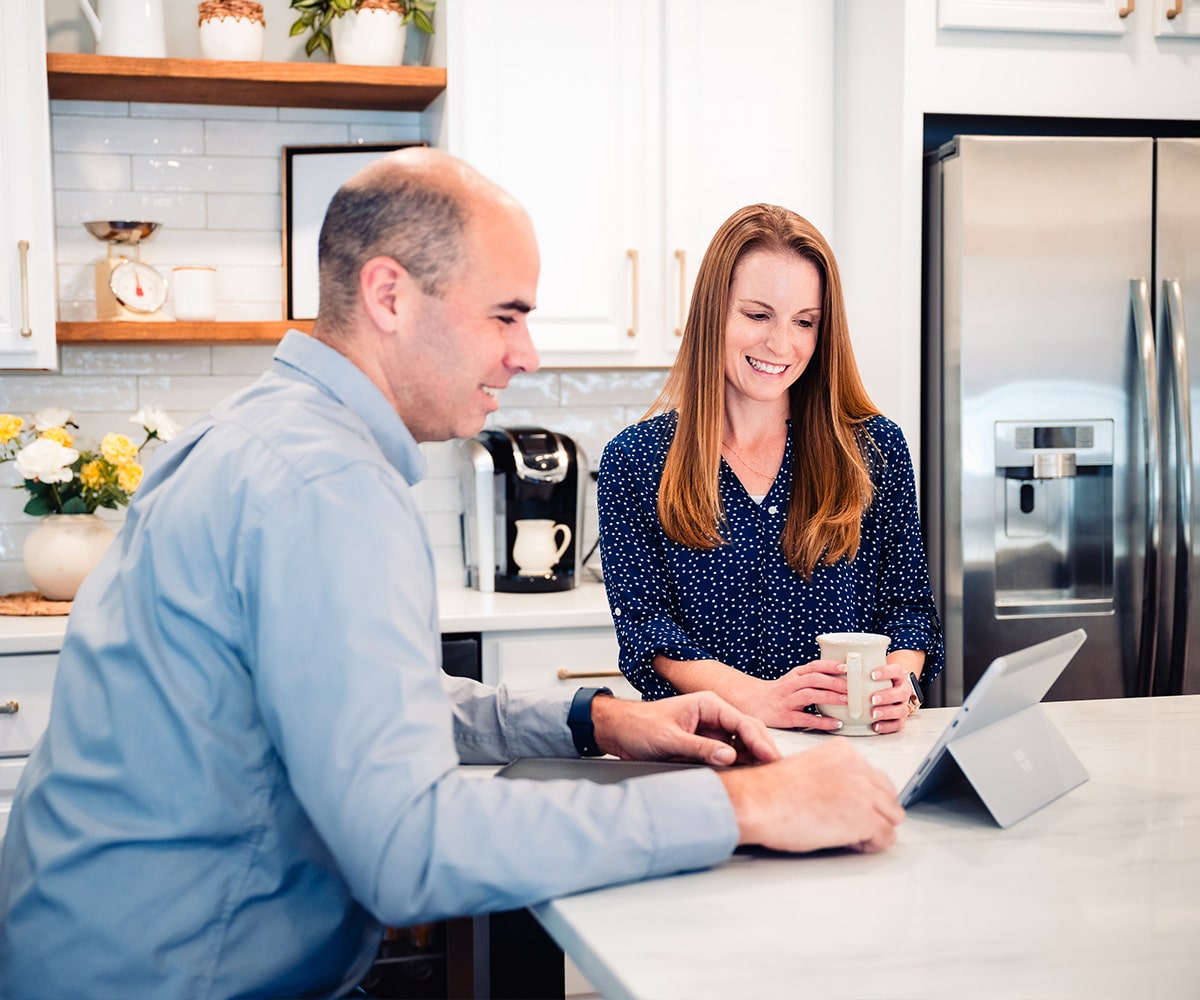 Triad electrician with customer in kitchen discussing work