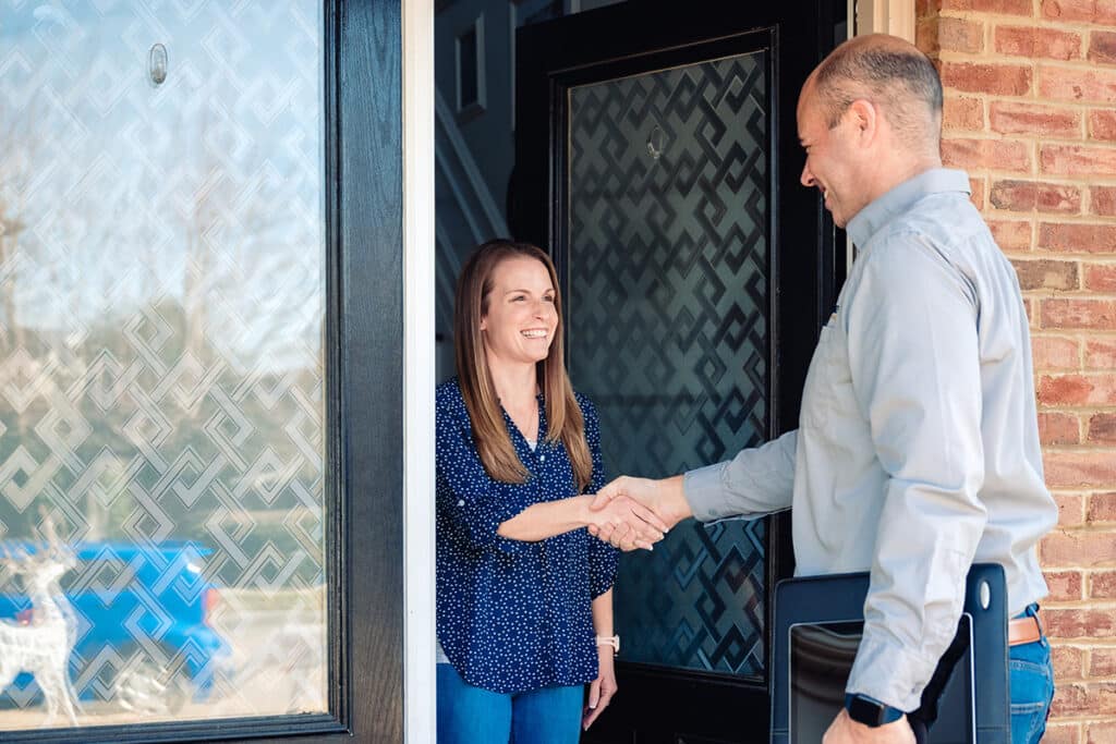 customer greets TRIAD tech in front of door