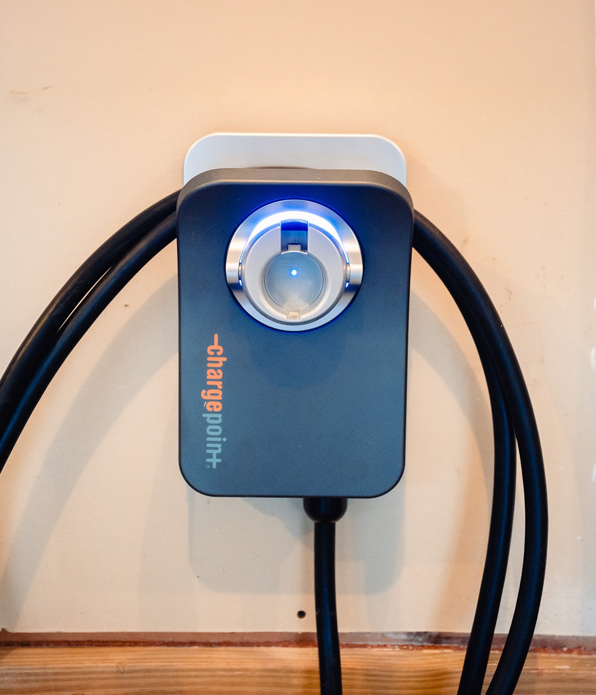 ChargePoint home EV charger with blue indicator light mounted on a garage wall, installed by Bee Bright Electrical in Cary, NC.